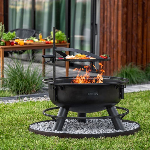 Cook King Bandito eldfat med höjdjusterbart grillgaller i användning i trädgårdsmiljö.