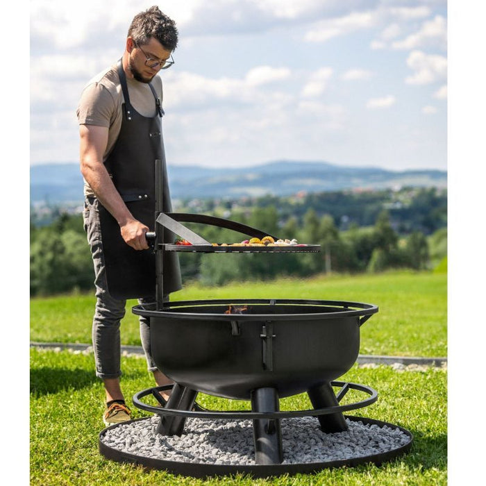 Man använder vredet för att reglera höjden på grillgallret ovanför elden i Bandito.