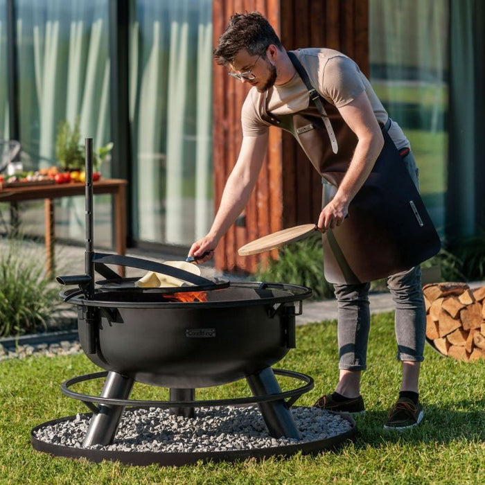 Man justerar tillbehör på höjdjusterbar mast i eldfatet Bandito från Cook King.