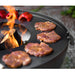 Närbild på grillplatta där köttbitar och paprikor grillas över öppen eld.
