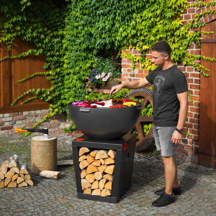 Person som grillar färska grönsaker på Santos barbecue från Cook King